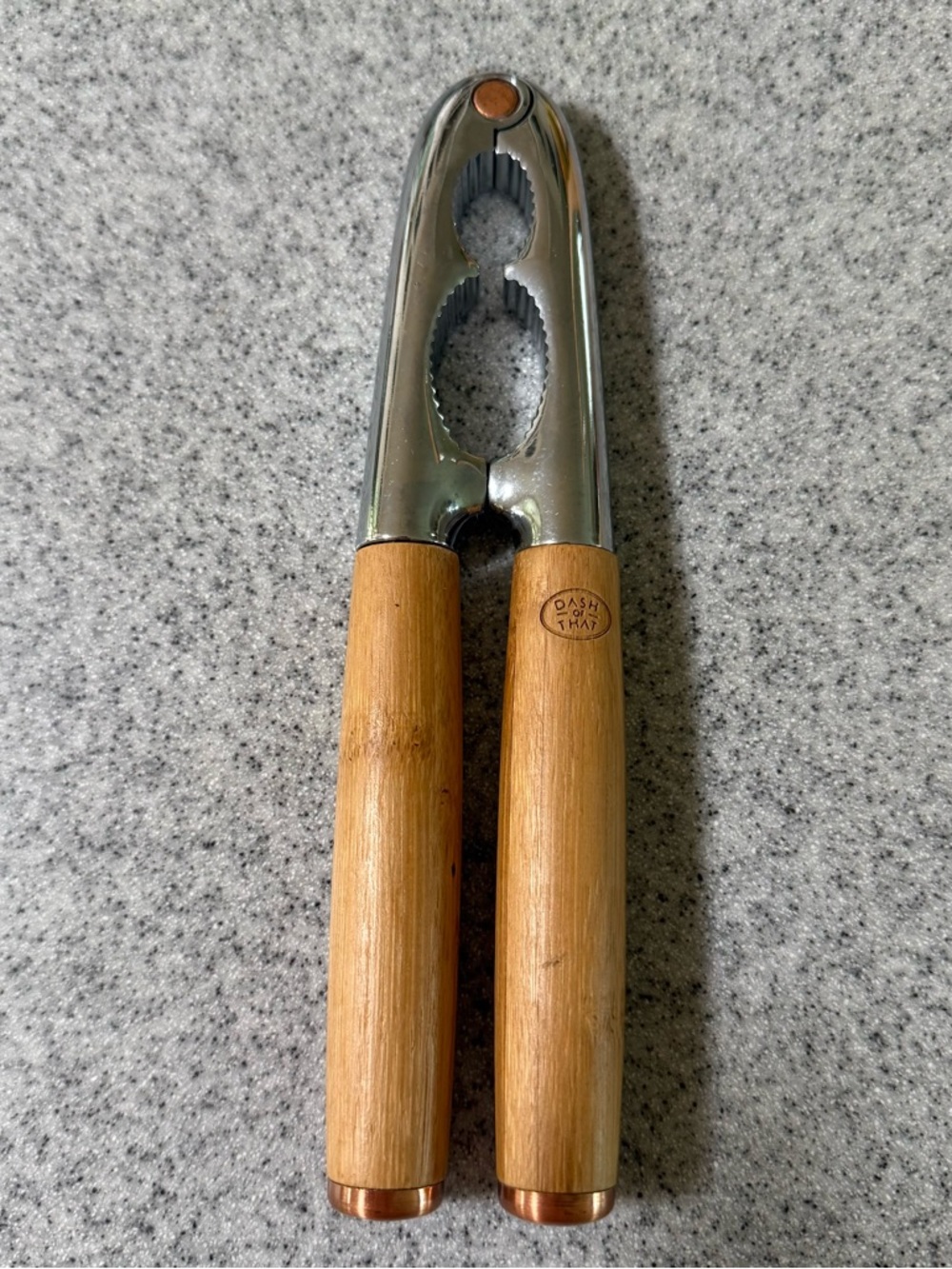 Dash of That Nut Cracker featuring natural bamboo handles and copper accents